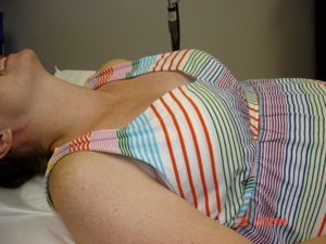 The patient reclines with a pillow under the shoulders and the neck slightly extended.